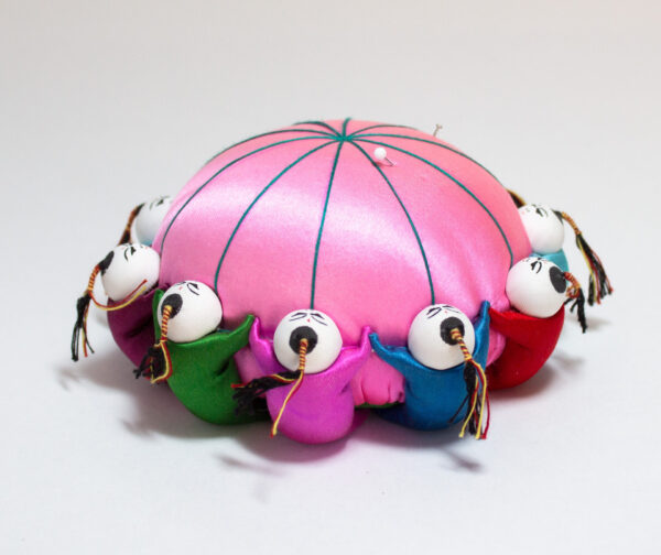 Pink Satin Pin Cushion With 10 Colorful Dolls Holding Hands