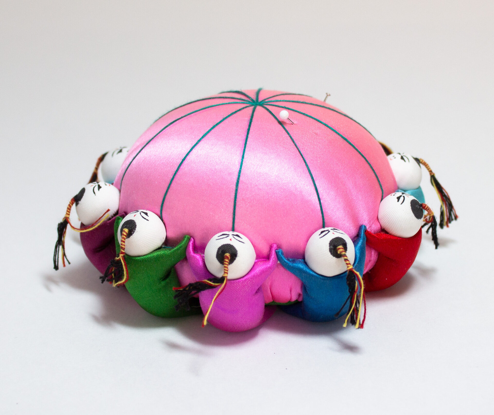 Pink Satin Pin Cushion With 10 Colorful Dolls Holding Hands